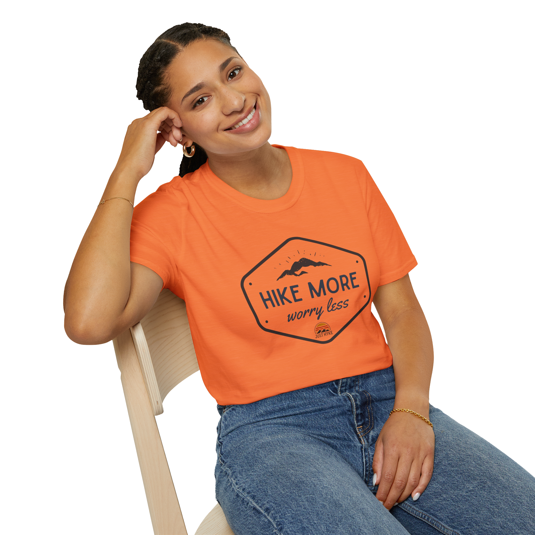 female sitting on chair wearing an orange tee shirt that says hike more worry less